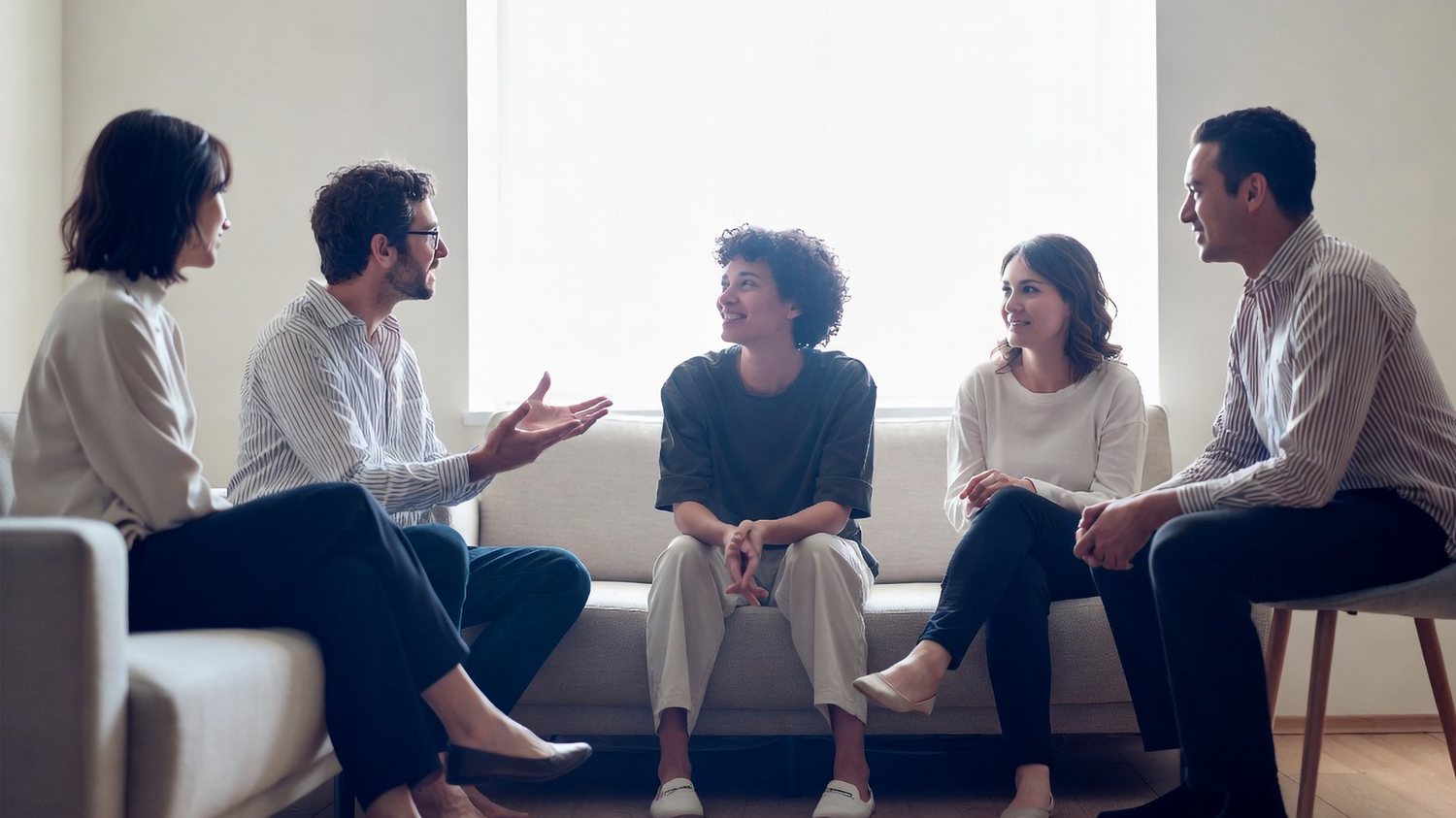 A therapy group seated together in a light-filled room